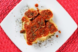 rondelli topped with red sauce and sprinkled with spices.